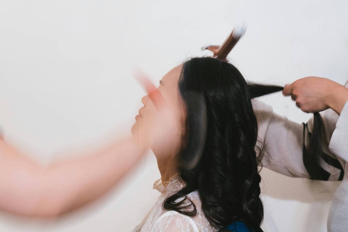 Side-by-side photo: before shows flat, single-tone brown hair; after shows dimensional, sun-kissed balayage with soft root shadow and blended ends.