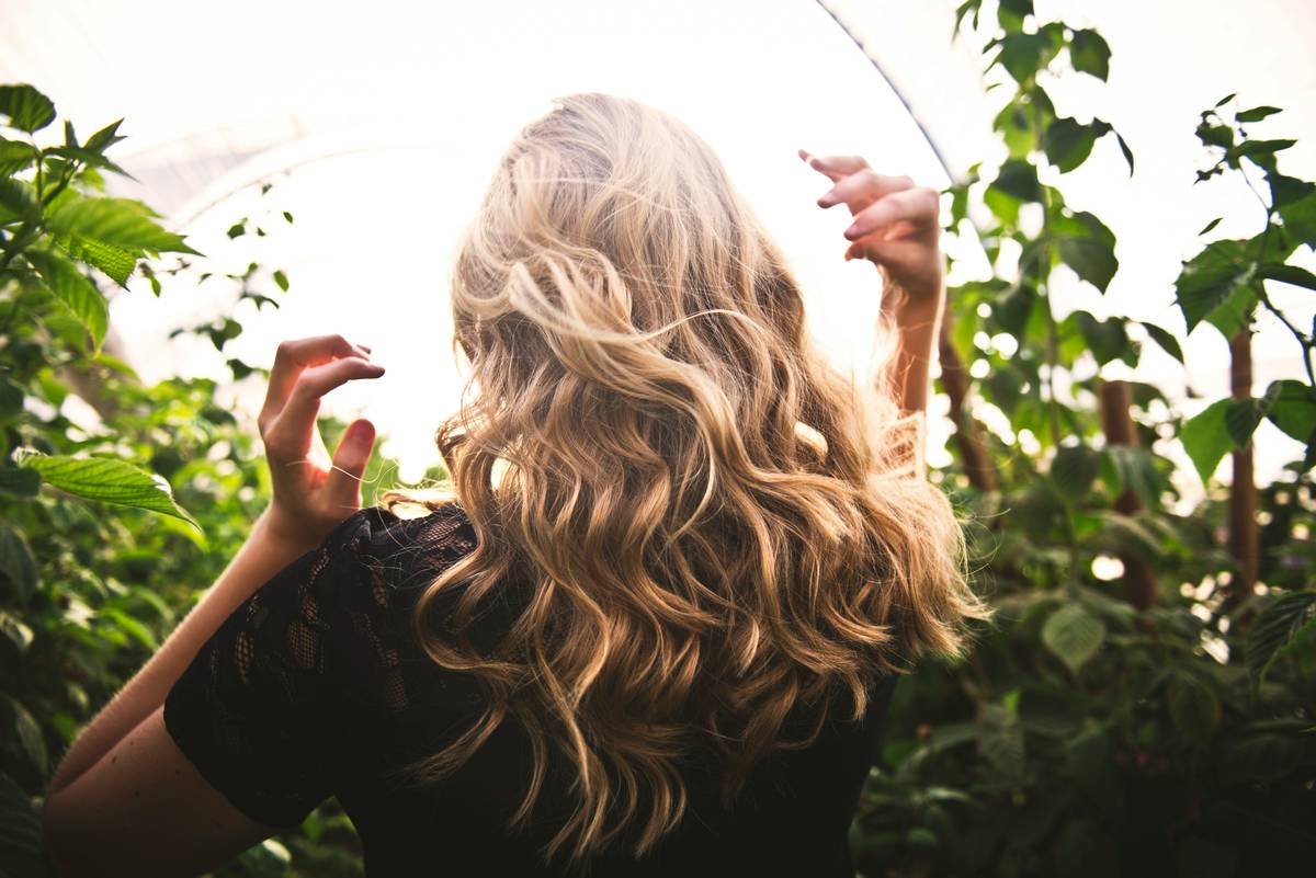 Woman applying ACV rinse to prevent balayage color fade