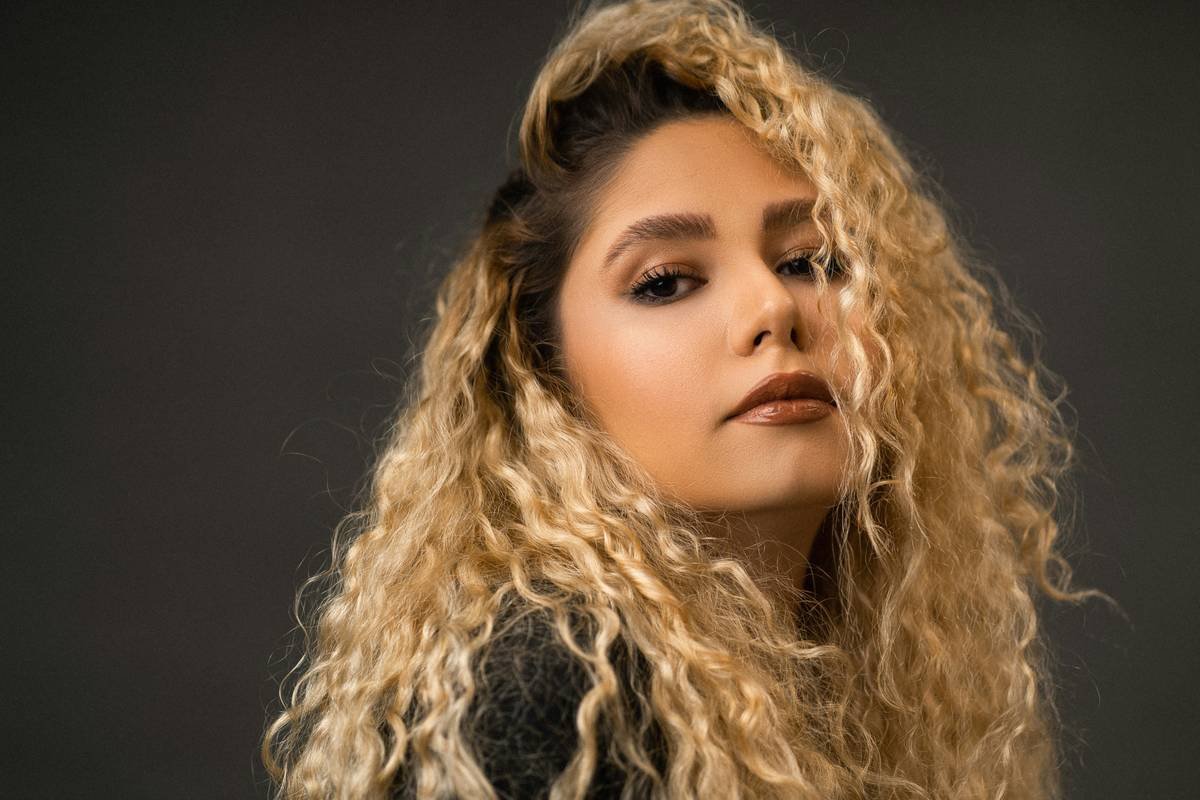 Stylist applying balayage hair wave technique on naturally wavy hair